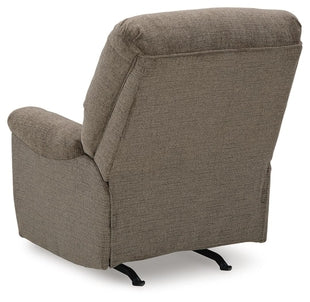 Ashley Stonemeade manual rocker recliner with plush fabric and wooden base, shown from the back in a cozy living room setting.