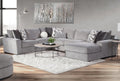Light grey U-shaped sectional sofa by Behold, showcasing plush upholstery and modern design in a spacious living room setting.