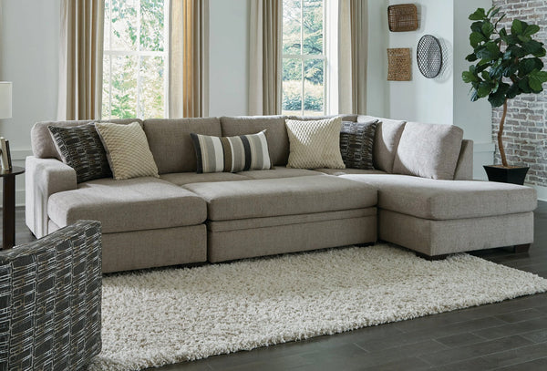 Brown U-shaped sectional sofa by Behold, showing plush cushions and wooden legs in a modern living room setting.