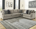 Brown Ashley L-shaped sectional sofa in a modern studio setting with plush cushions and sleek design.