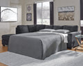Slate grey Ashley L-shaped sleeper sectional sofa in a modern studio setting, showcasing its sleek design and spacious seating.