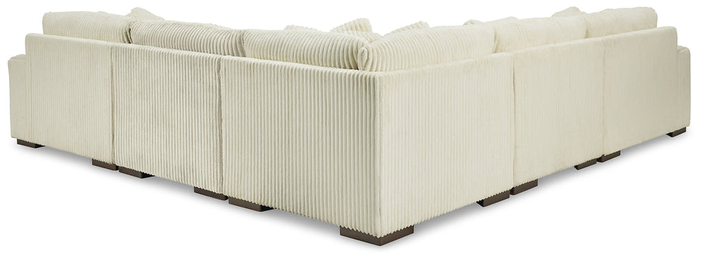 Ivory corduroy L-shaped sectional sofa by Ashley, featuring plush cushions and a modern design in a studio setting.