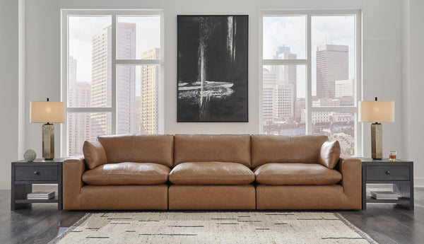 Genuine leather 3-piece sectional sofa by Ashley in a modern studio setting, featuring plush cushions and sleek design.