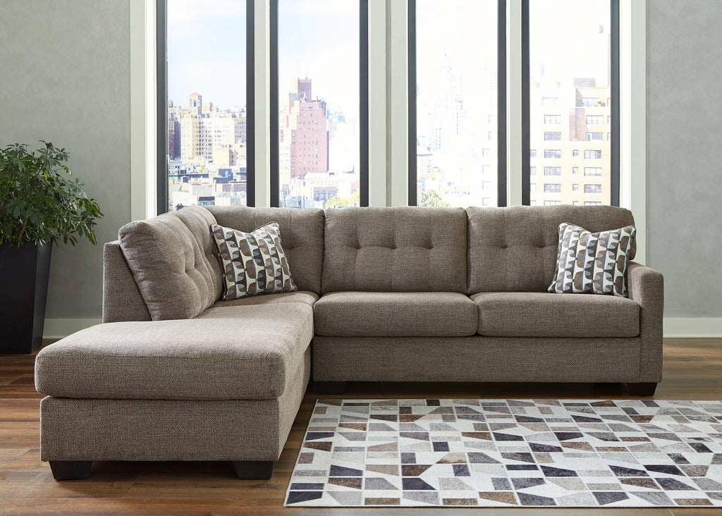 Brown Ashley L-shaped sectional sofa in a modern studio setting, showcasing plush cushions and spacious seating arrangement.