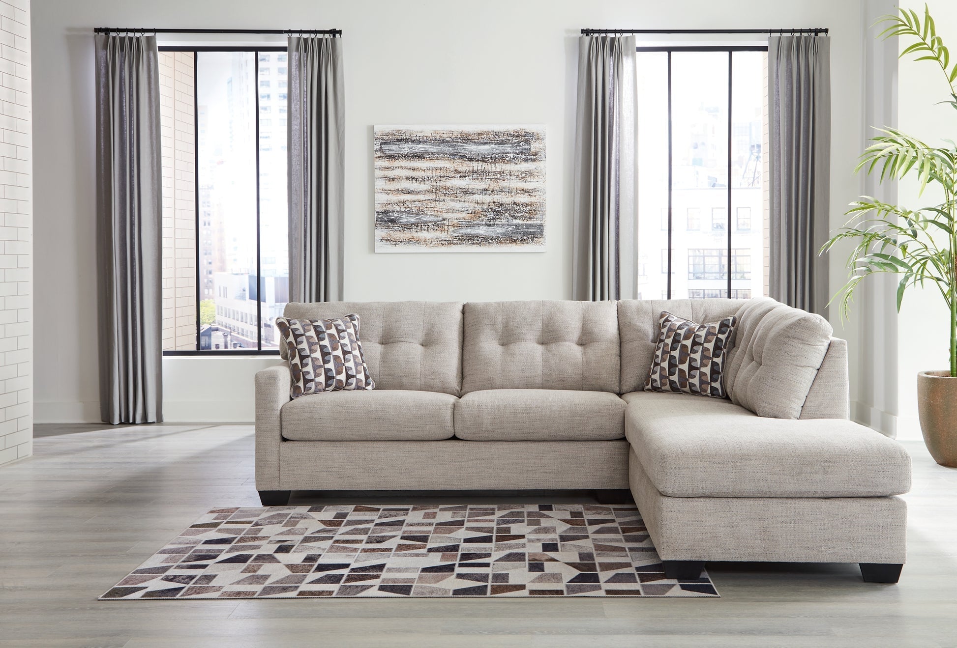 Beige Ashley L-shaped sectional sofa with plush cushions and modern design, shown in a stylish living room setting.