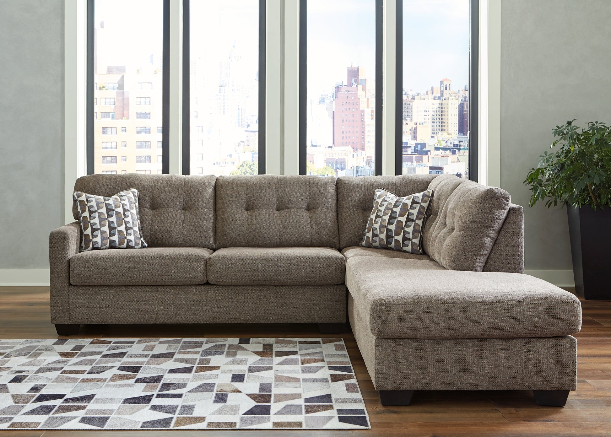 Brown Ashley L-shaped sectional sofa with plush cushions and wide armrests, shown in a modern living room setting.