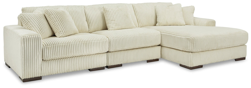 Ivory corduroy sofa chaise by Ashley, showing plush fabric and sleek design in a modern living room setting.