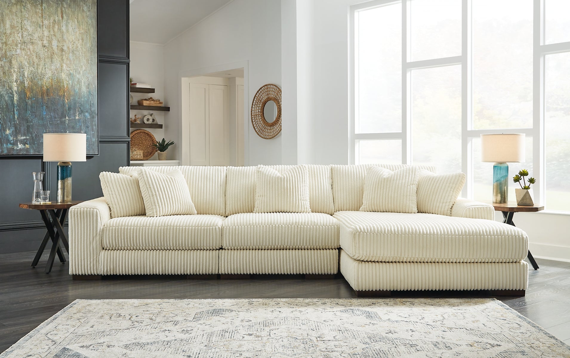 Ivory corduroy sofa chaise by Ashley, featuring plush cushioning and modern design, shown in a stylish studio setting.