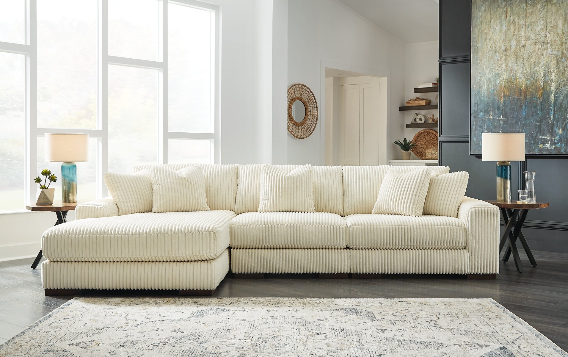 Ivory corduroy sofa chaise by Ashley with plush cushions and a modern design in a studio setting.