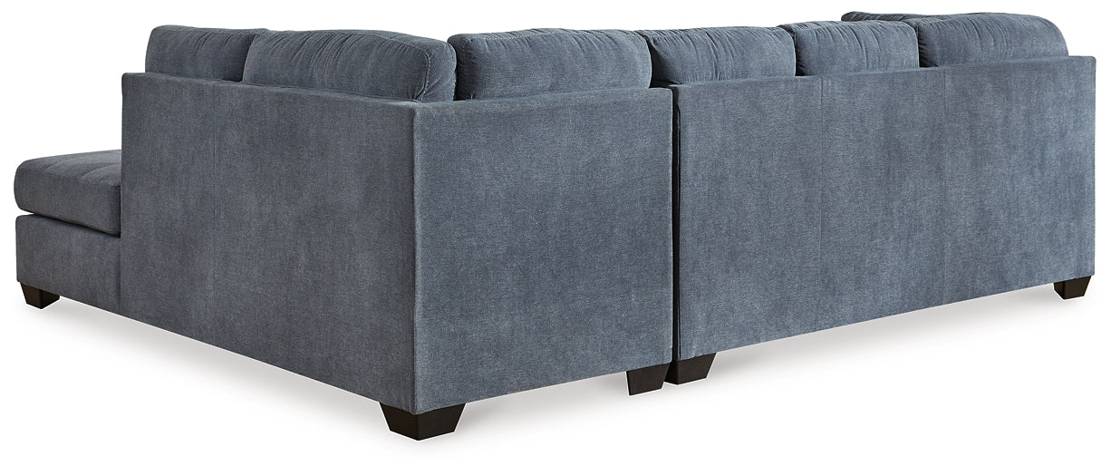 Blue Ashley L-shaped sectional sofa in a modern studio setting, showcasing plush cushions and sleek fabric upholstery.