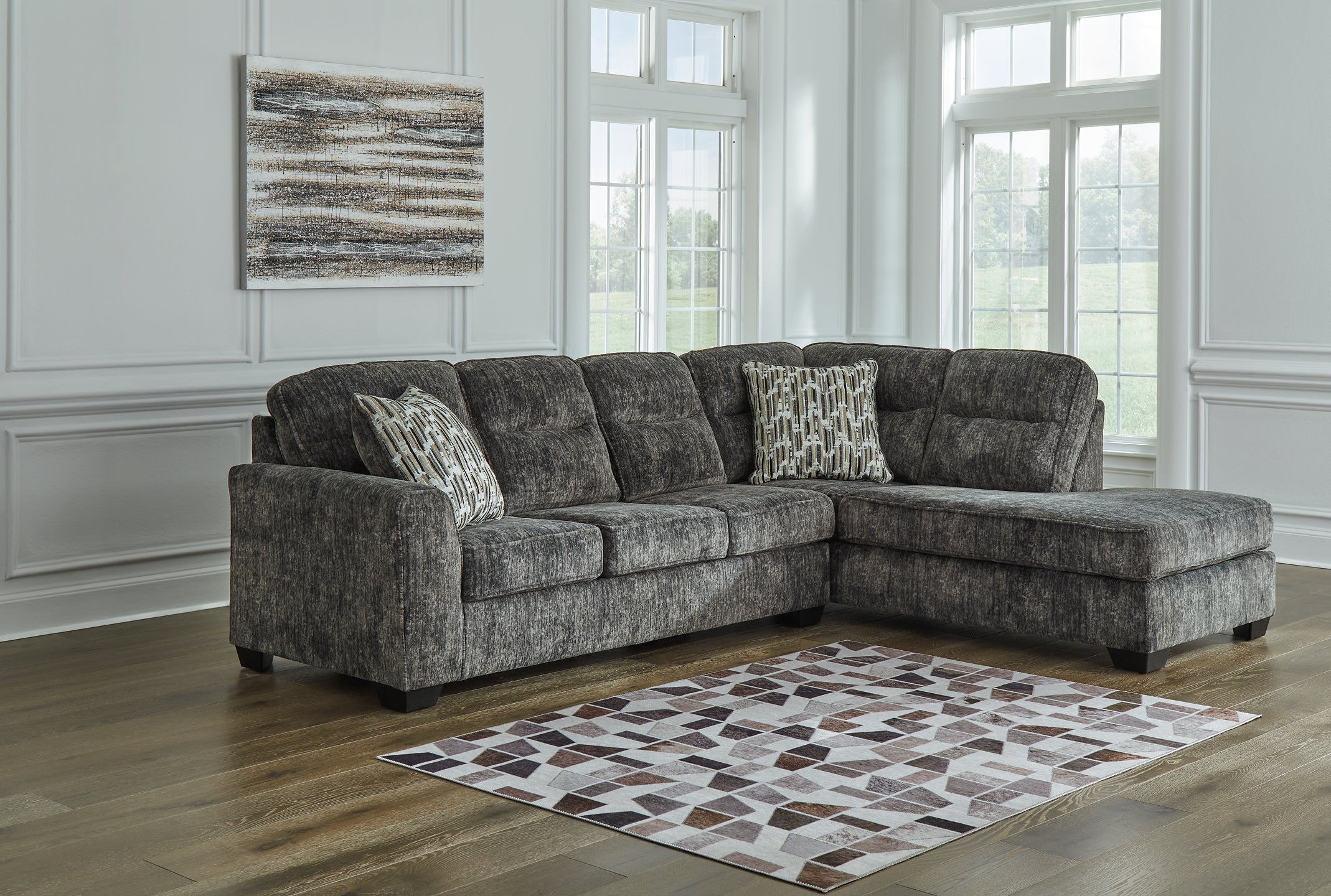 Grey Ashley L-shaped sectional sofa with plush cushions and modern design, shown in a stylish living room setting.