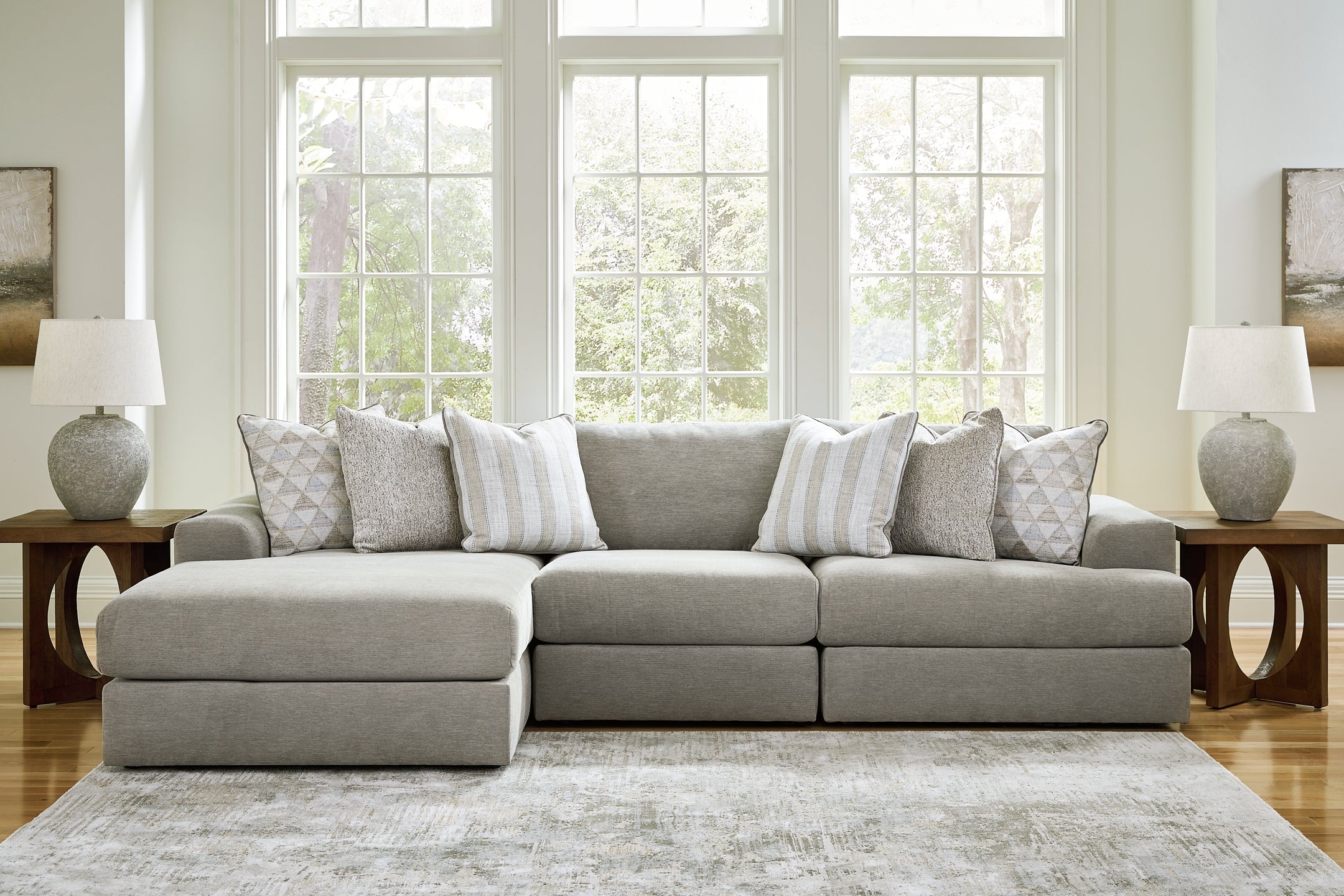 Grey Ashley sofa chaise with plush cushions and modern design, shown from a studio setting highlighting its stylish comfort.