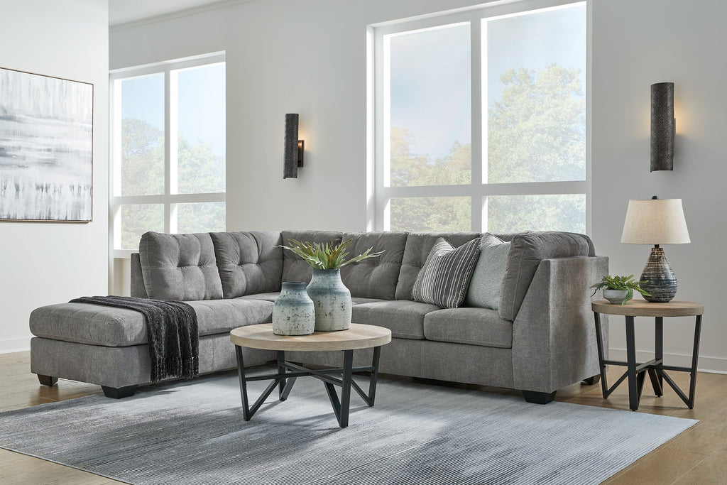 Grey Ashley L-shaped sectional sofa in a modern studio setting, highlighting the spacious design and plush cushions.