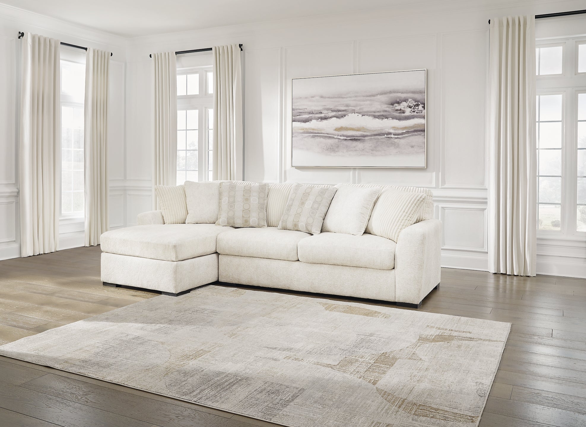 Ivory Ashley sofa chaise with plush cushions and wooden legs, styled in a modern living room setting.