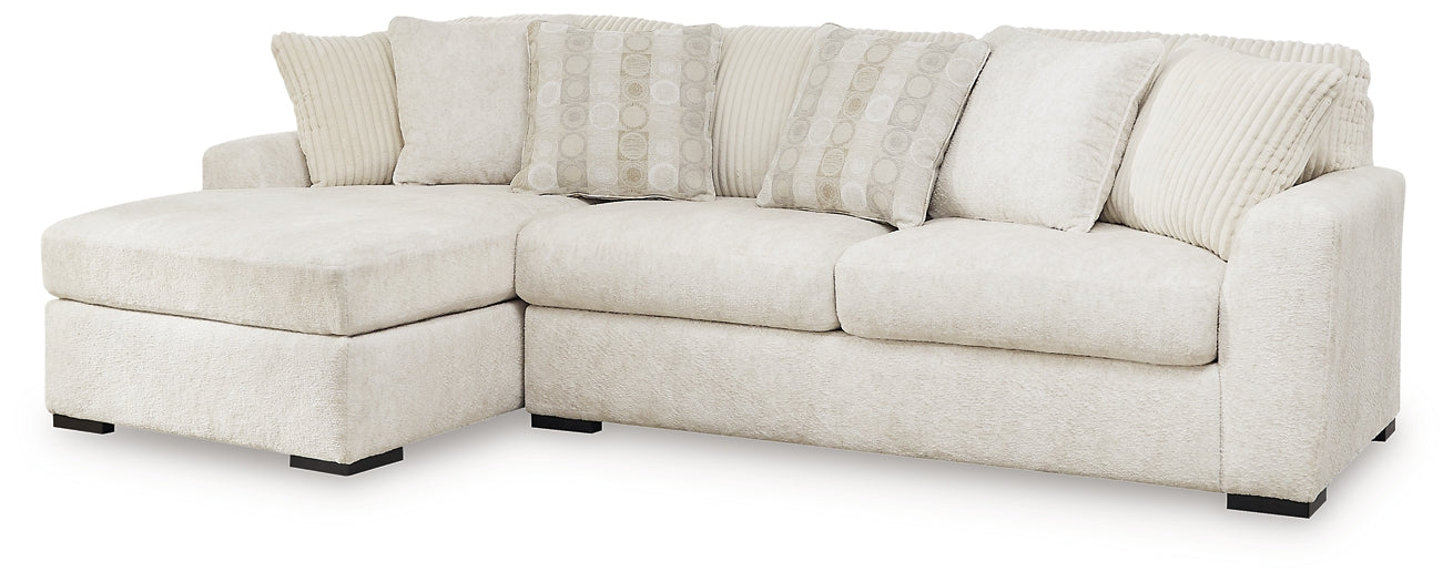 Ivory Ashley sofa chaise with plush cushions, modern design, and wooden legs, photographed in a studio setting.