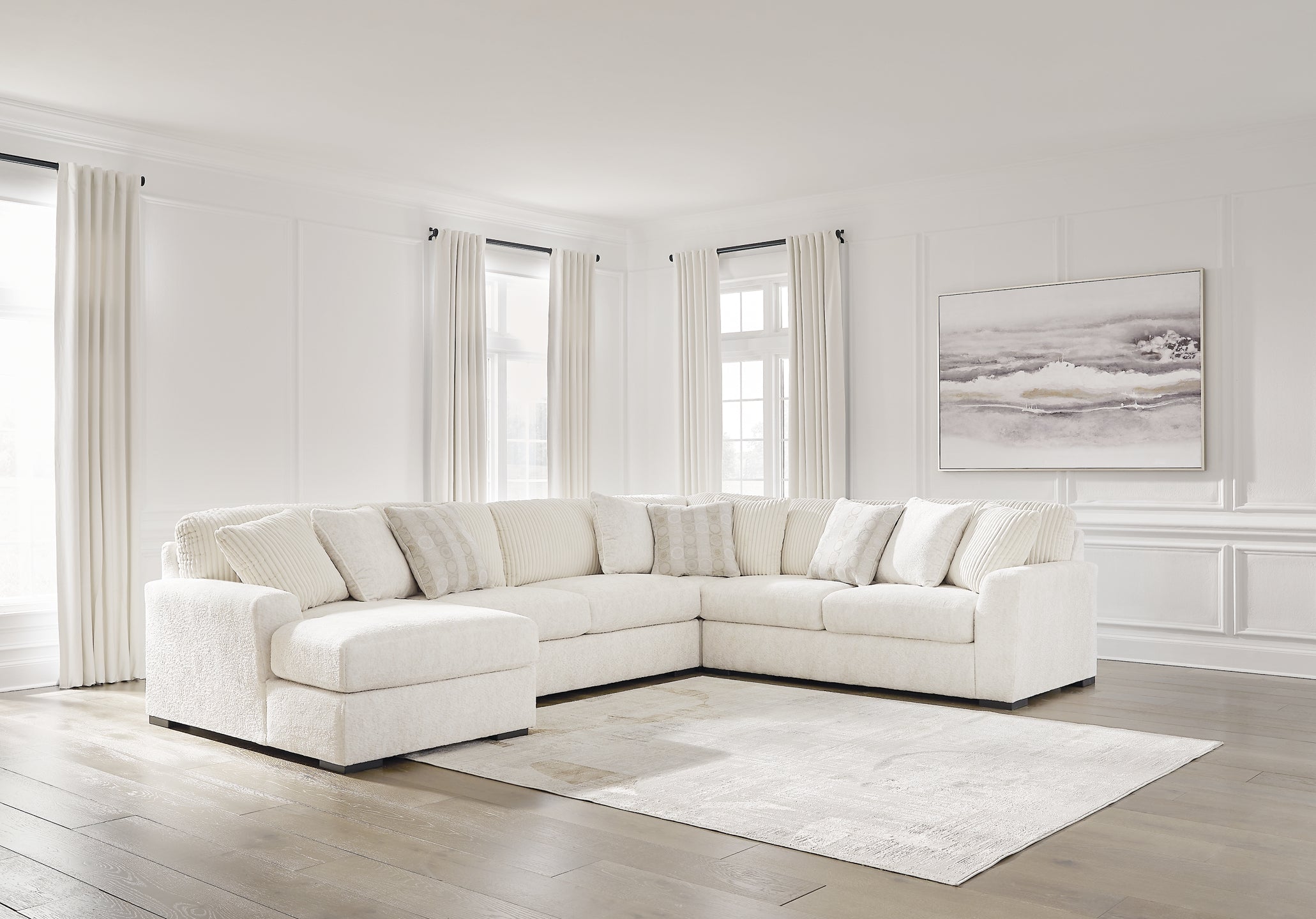 Ivory U-shaped sectional sofa by Ashley with plush cushions and modern design, shown in a stylish living room setting.