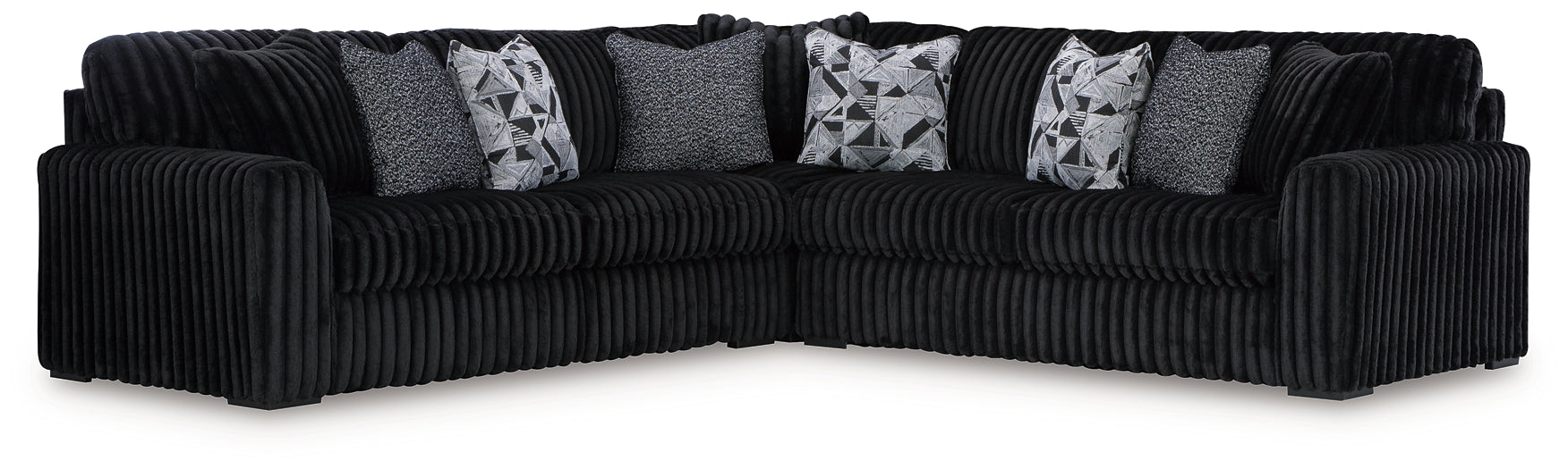 Black corduroy L-shaped sectional sofa from Ashley, shown in a modern studio setting with plush cushions and spacious seating.