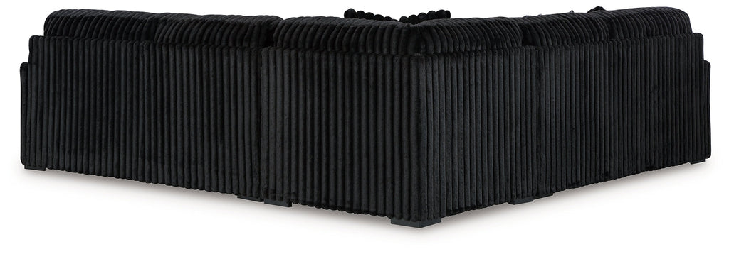 Black corduroy L-shaped sectional sofa by Ashley, showing the plush fabric and modern design in a studio setting.