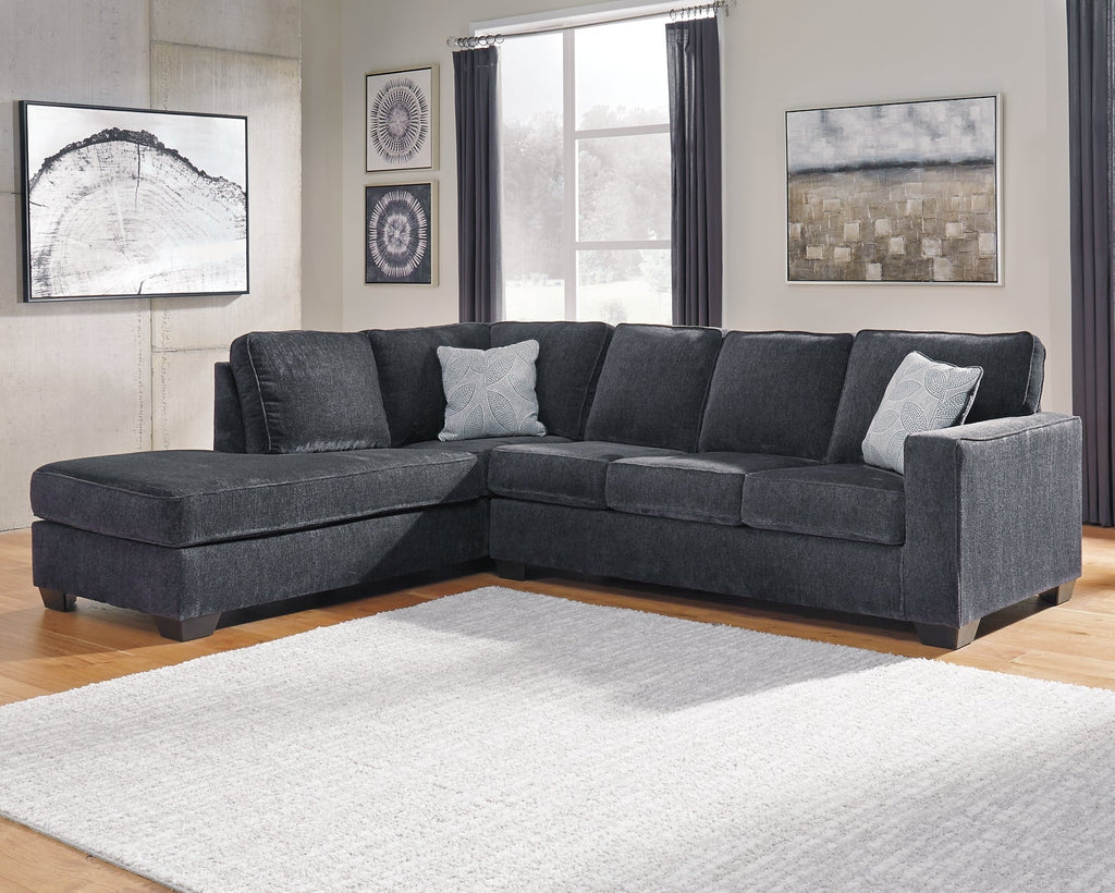 Slate grey Ashley L-shaped sleeper sectional sofa in a modern studio setting, showcasing the fabric and spacious design.