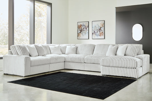 Ivory corduroy U-shaped sectional sofa by Ashley, shown in a modern studio setting with plush cushions and sleek design.