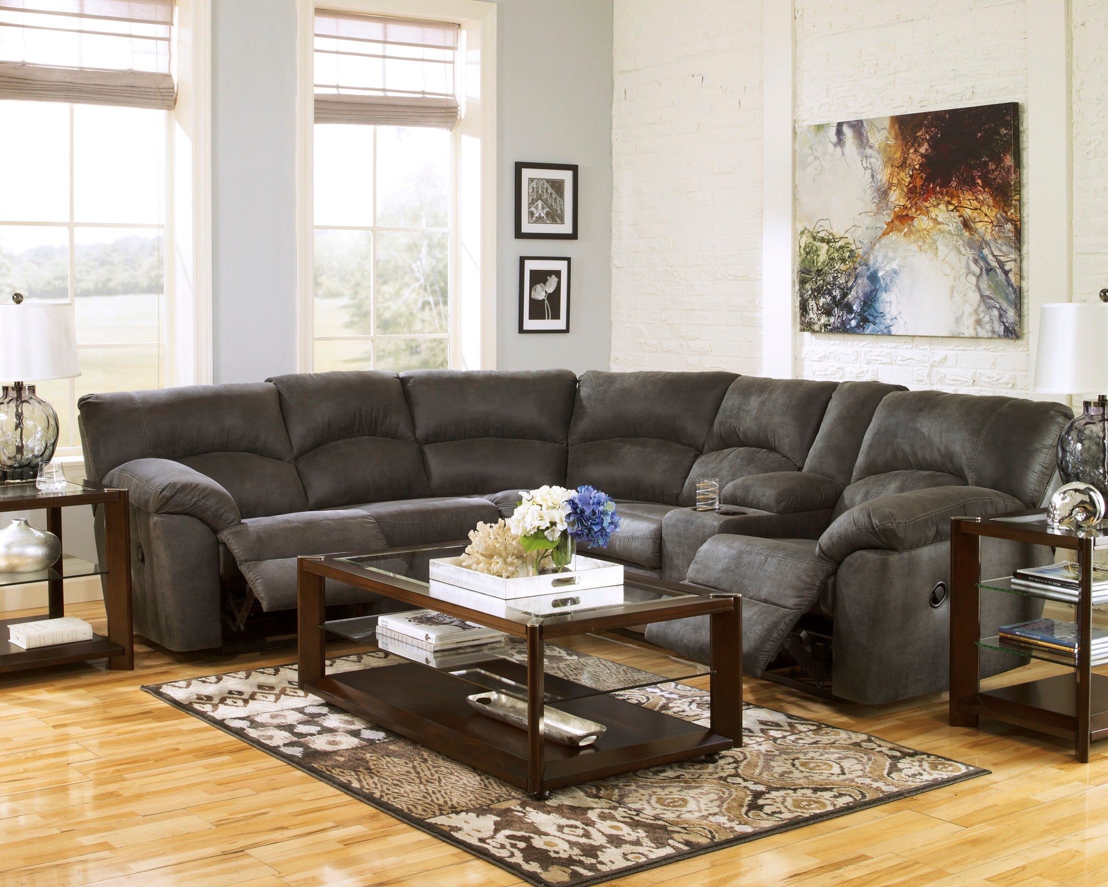 Ashley faux leather reclining sectional in pewter with plush cushions and adjustable reclining seats for comfortable seating.